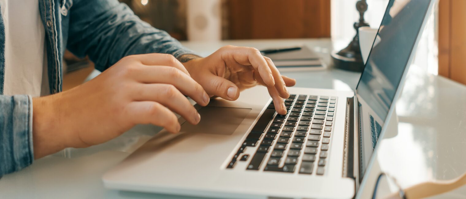 Close-up of male hands with laptop.