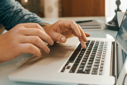 Close-up of male hands with laptop.